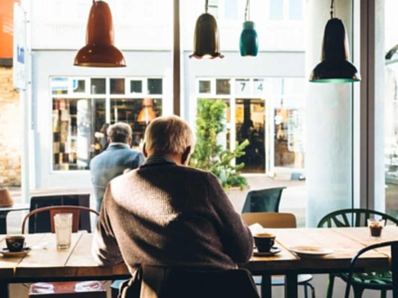 Man Sitting At Table In Coffee Shop