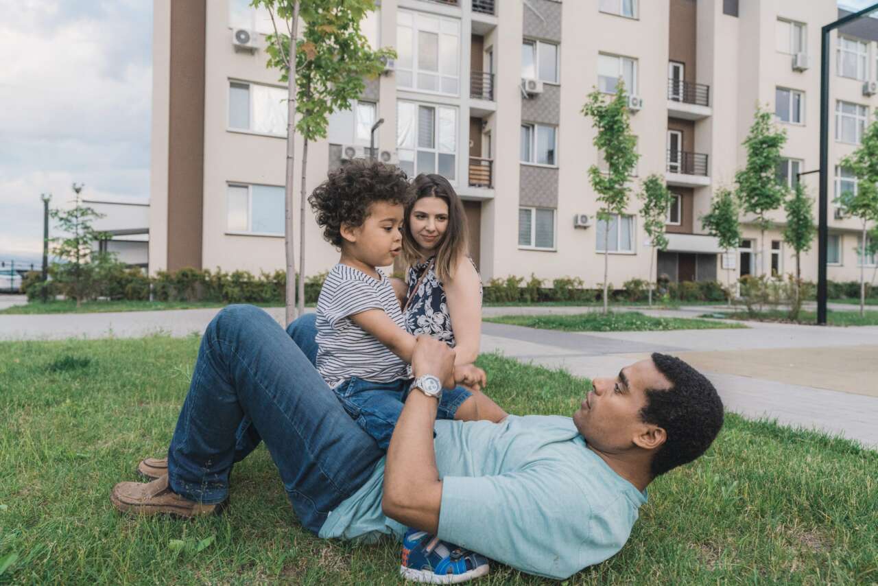 Family playing outside apartment